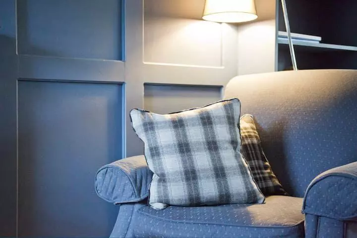 Living room with blue wall panelling and wood burner